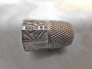 An engraved silver thimble. HM. 1889. Maker HG.