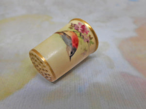 A blush ivory Worcester porcelain thimble painted with a redstart. c1870.
