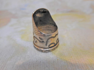 An engraved silver finger guard / thimble. Mid 19th century.