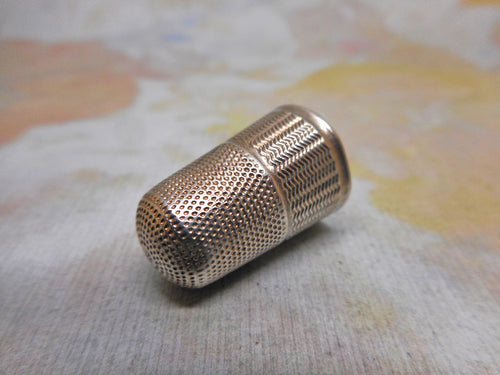 A silver thimble with engine turned decoration. English c1860
