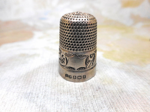 A decorative silver thimble.  H.M. 1905