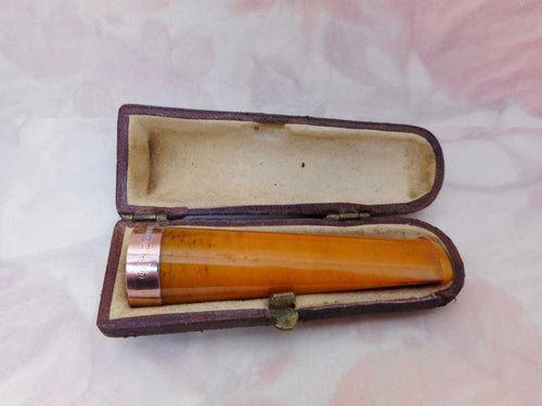 A boxed amber cheroot holder. 9ct gold band. Edwardian.