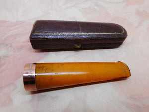 A boxed amber cheroot holder. 9ct gold band. Edwardian.