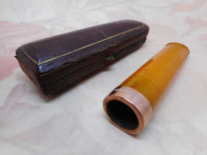 A boxed amber cheroot holder. 9ct gold band. Edwardian.