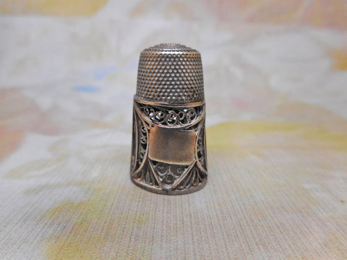 An early 19th century silver filigree thimble and case.