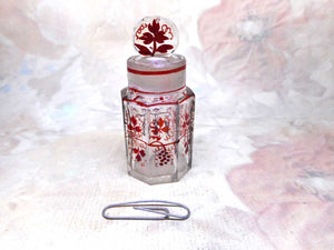 A small glass smelling salts bottle with vine decoration.