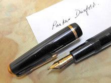 Load image into Gallery viewer, A black pen titled &#39;Parker Duofold Made in England&#39; on the barrel. The nib is 14kt gold also by Parker and likely to be the original.   There&#39;s no damage and it is working.  14cm long 5.5 inches long    
