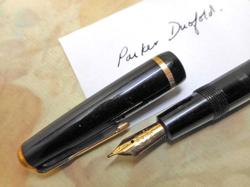 A black pen titled 'Parker Duofold Made in England' on the barrel. The nib is 14kt gold also by Parker and likely to be the original.   There's no damage and it is working.  14cm long 5.5 inches long    