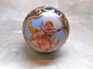 A Continental porcelain parasol handle painted with cherubs. c1880