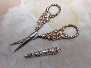 A pair of silver 'bird' handled scissors and sheath. c 1830-1840