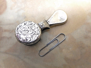 A silver plated curio- for polishing the glass on a dental mirror / spectacle lens?