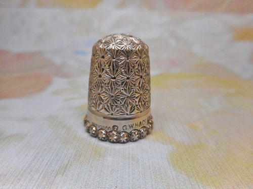 A silver thimble with star border. Chester 1899.