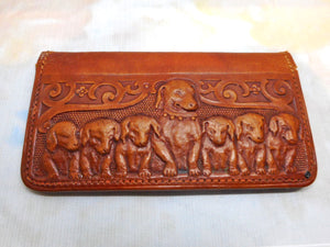 A charming tan leather stamp / card case embossed with a row of hounds.