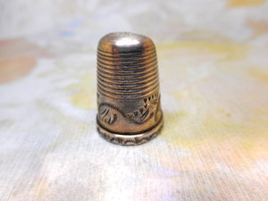 An engraved silver finger guard / thimble. Mid 19th century.