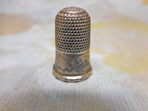 A very small silver thimble for a child. c 1840