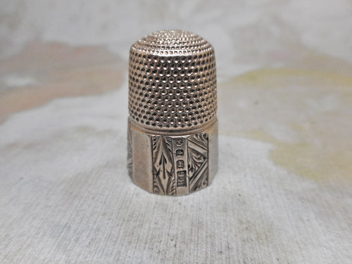 An engraved silver thimble. HM. 1889. Maker HG.