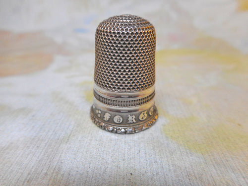 A Georgian silver thimble embossed with 'Forget Me Not'. c1830