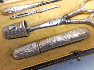 A silver plated set of sewing tools embossed with mistletoe. c1900
