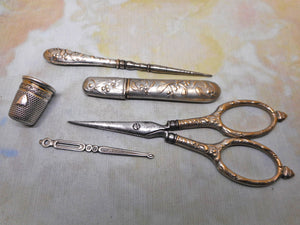 A silver plated set of sewing tools embossed with mistletoe. c1900
