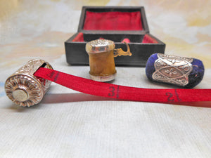 A cased sewing set -a silver tape measure, waxer and emery. c1850