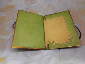 A tooled leather needle case with petit point panels. c 1860.