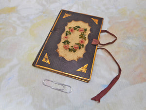 A tooled leather needle case with petit point panels. c 1860.