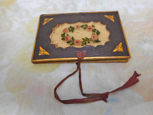 A tooled leather needle case with petit point panels. c 1860.
