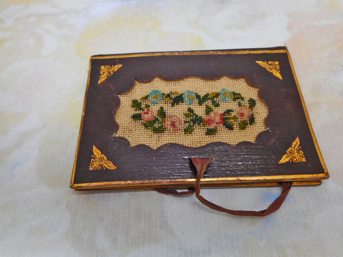 A tooled leather needle case with petit point panels. c 1860.