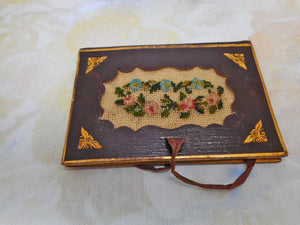A tooled leather needle case with petit point panels. c 1860.
