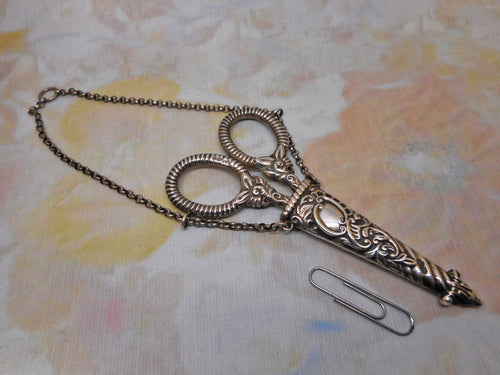 A silver scissor case and scissors from a chatelaine. GU. 1897