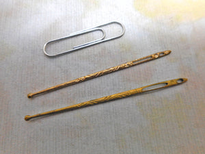 Two decorative gilt metal bodkins. c 1900