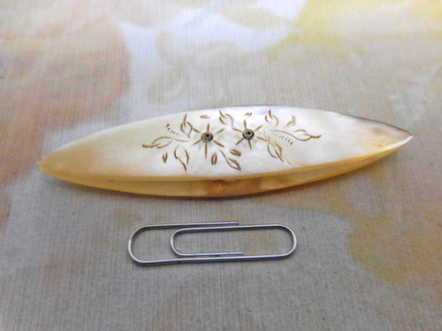 Antique pearl tatting shuttle engraved with flowers.