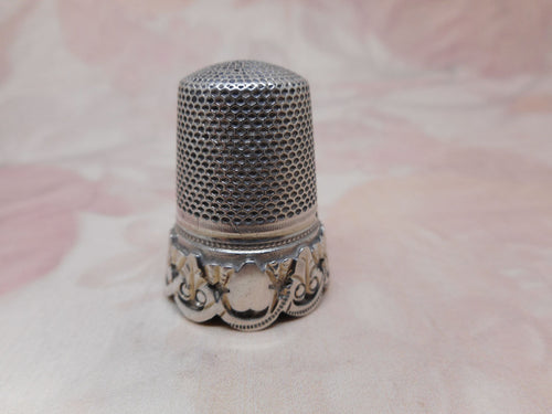 An antique French silver thimble with an apllied decorative border. c1870
