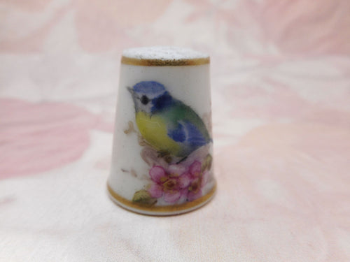 A Royal Worcester porcelain thimble painted with a bird. Purple stamp c 1920