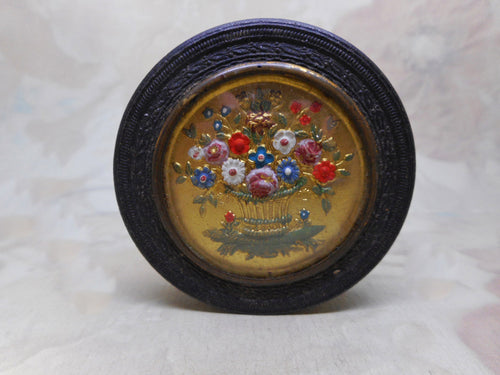 An antique French bonbon box with floral decoration.