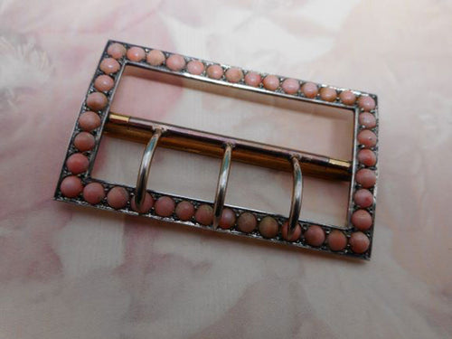 A silver gilt buckle set with corals. c 1900