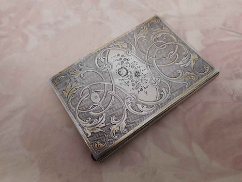 A French silver notebook with gilt highlighting. c1870