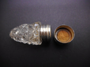 A small cut glass scent bottle with silver lid. HM. 1909.