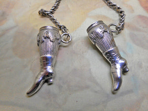 SOLD……A pair of silver knitting needle ends -lady's stockinged legs. Late 19thc