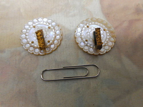 A pair of mother of pearl cloak clasps.