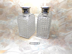 A pair of cut-glass scent bottles with screw on silver lids. c 1860