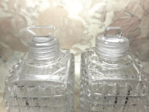 A pair of cut-glass scent bottles with screw on silver lids. c 1860