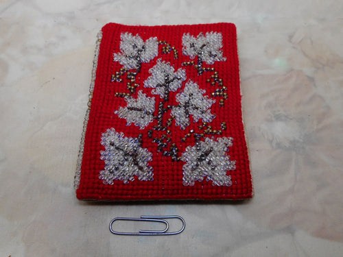 A cross stitched needle case with beadwork decoration. circa 1860