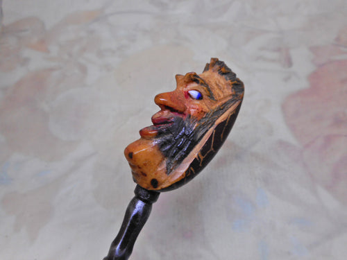 A vegetable ivory button hook carved with a grotesque head. 19thc