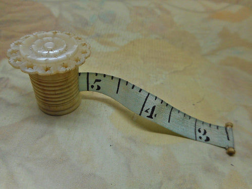 A pearl topped tape measure from a sewing box. c 1850