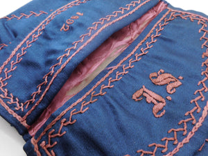 An embroidered blue silk wallet dated 1892.