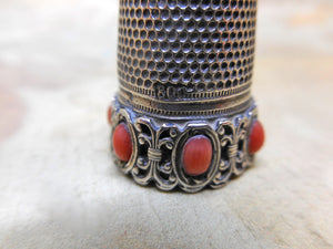 A German silver thimble with coral coloured beading. Late 19th century.