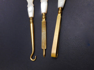 Three gilt steel hand tools with pearl handles. c 1870