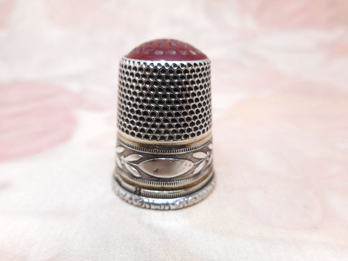 A Continental silver thimble with a stone top. 19th century.